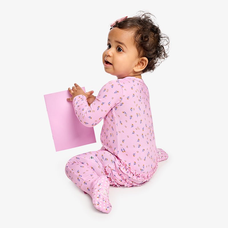 Baby in a pink one piece zipper footie pajama with fold-over cuffs