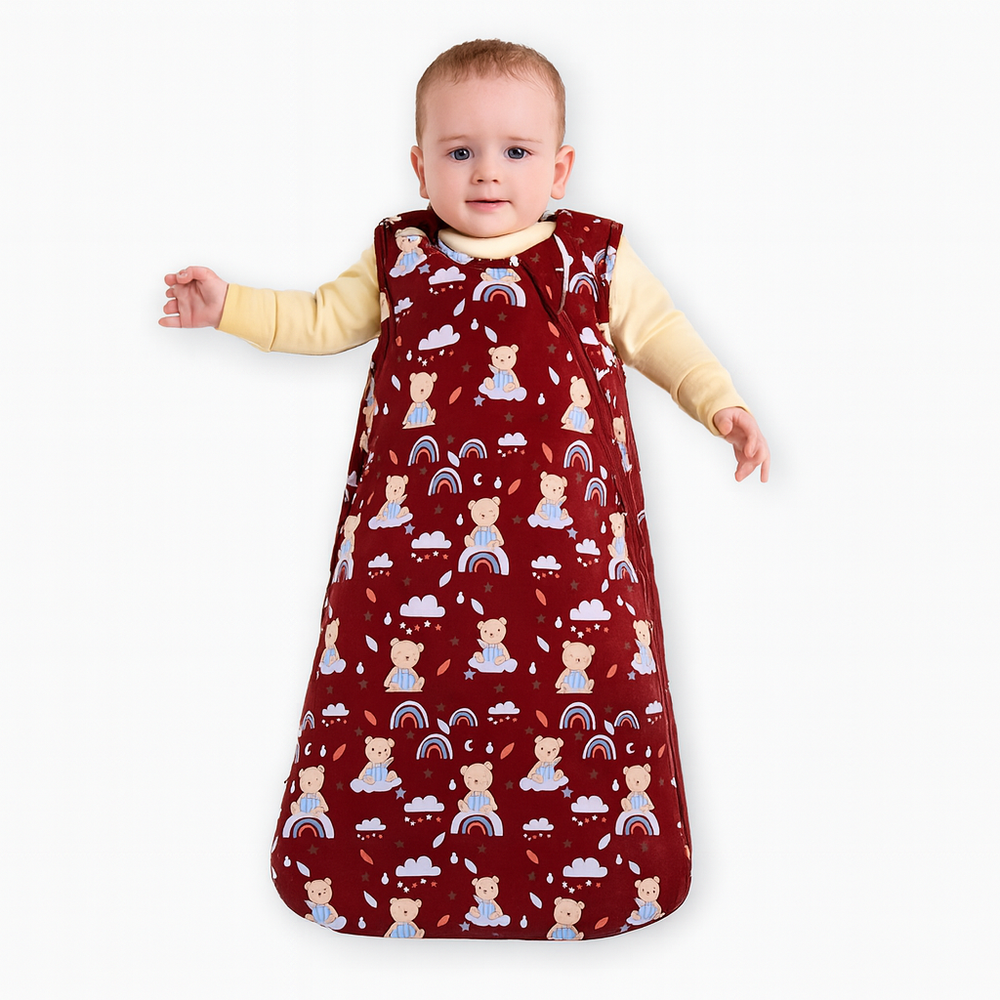 Baby wearing a red patterned sleep bag on a white background
